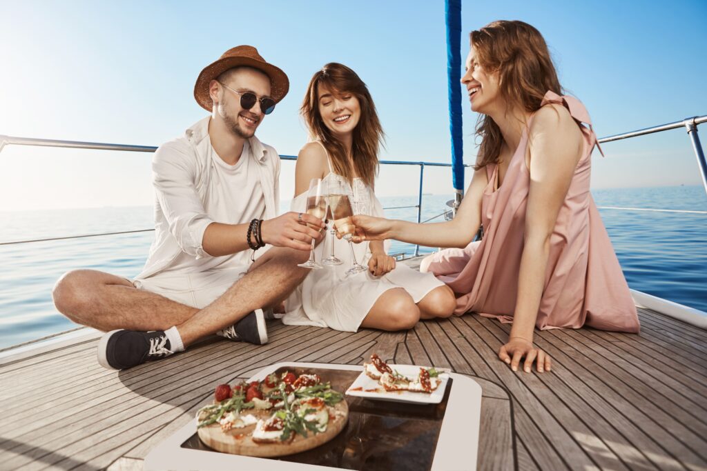 three-trendy-european-friends-sitting-boat-having-lunch-drinking-champagne-expressing-joy-pleasure-every-year-they-book-tickets-warm-countries-winter - Secret World